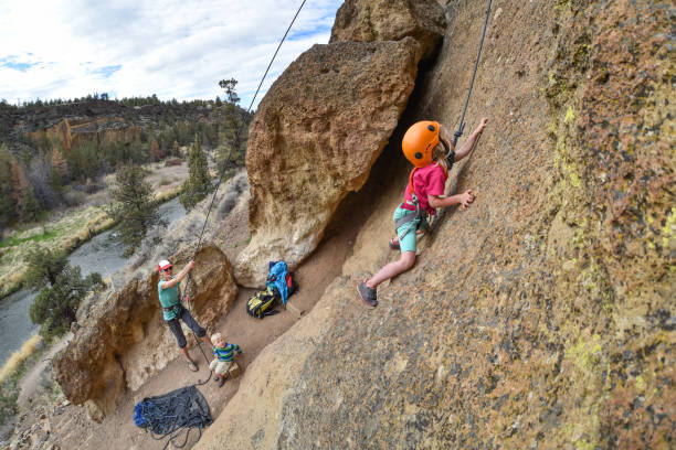 Mother and daughter rock climbing stock photo