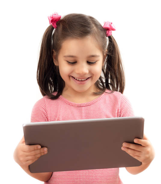 счастливая маленькая девочка, используя цифровой планшет, изолированный на белом фоне - ipad mini ipad white small стоковые фото и изображения