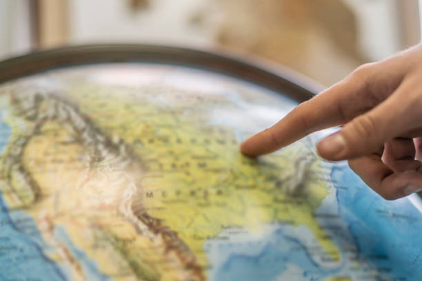 istock persons finger point at globe and choose destination b 1134410064