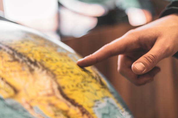 istock persons finger point at globe and choose destination b 1134410067