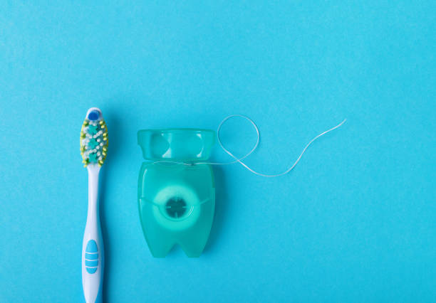 istock Dental floss and toothbrush on a blue background. Space for text. 1134410211