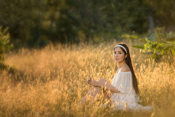 istock beautiful young woman sitting in a meadow 1134411775