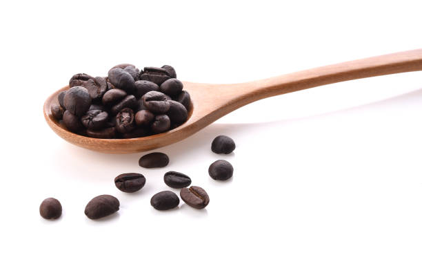 istock Fresh coffee beans with wooden spoon isolated on white background 1134413634
