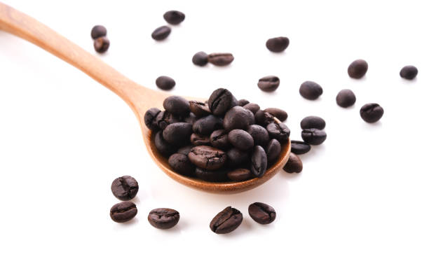 istock Fresh coffee beans with wooden spoon isolated on white background 1134416124