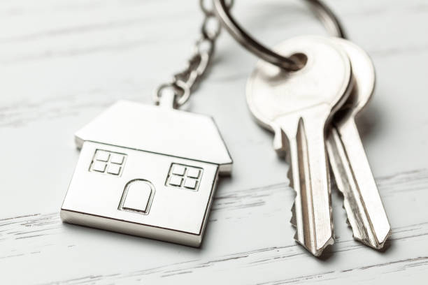 istock Keychain house and keys on white wooden background 1134417256