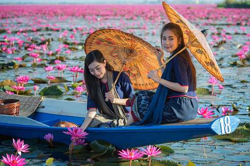 Pretty girl and the sea of red lotus , Thailand .