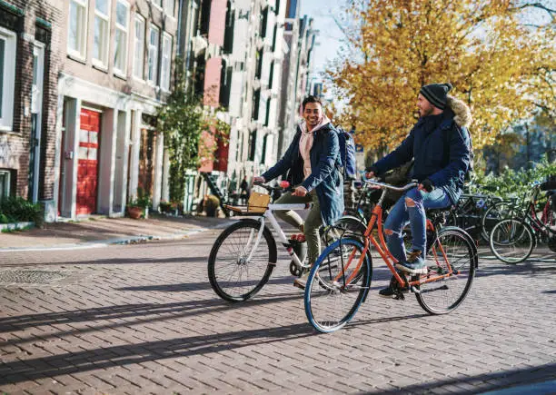 Photo of LGBT couple on city break - diverse millennial gay guys are in relationship and spending time on city break