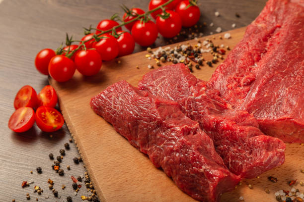 istock Raw beef on a wooden background with spices and vegetables 1134437403