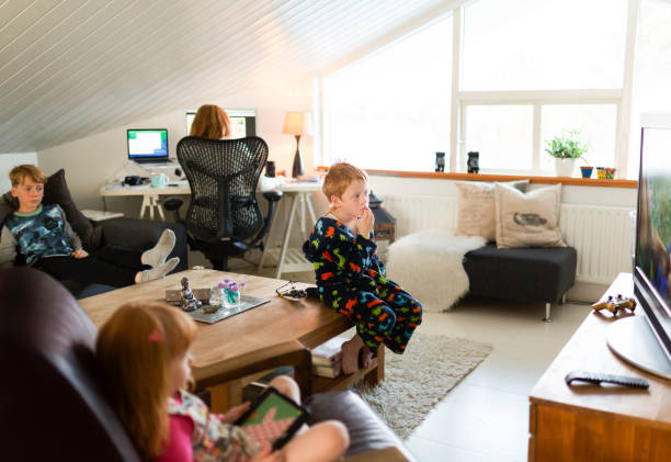 frau arbeitet am computer, während kinder entspannen - sibling brother family with three children sister stock-fotos und bilder