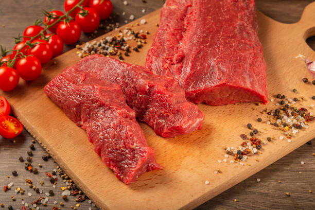 istock Raw beef on a wooden background with spices and vegetables 1134439380
