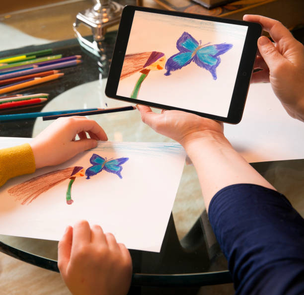 istock Mother and daughter holding tablet PC with drawing 1134439850