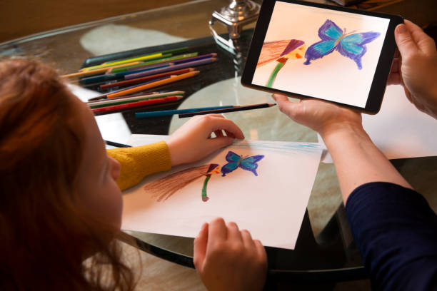 istock Mother showing tablet PC with drawing to daughter 1134439910