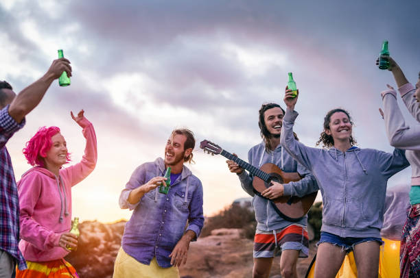 istock Happy friends making party at sunset while camping next the beach - Young people having fun dancing and drinking beer outdoor - Millennial, summer, vacation and youth holidays lifestyle concept 1134444614