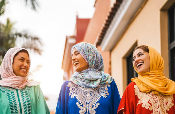 femmes musulmanes heureuses marchant dans le centre-ville-les jeunes filles arabes ayant le plaisir de passer du temps et de rire ensemble en plein air-concept de personnes, la culture et la religion - tradition marocaine photos et images de collection
