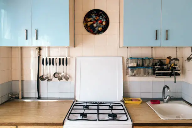 Photo of Simple kitchen interior with shabby wall cabinets in old house