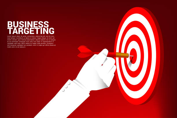 istock close up businessman hand with dart arrow to hit the dartboard. 1134445345