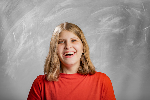 Blonde girl laughing smiling portrait in studio