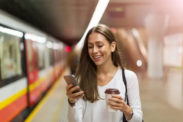 Woman using mobile phone at subway station