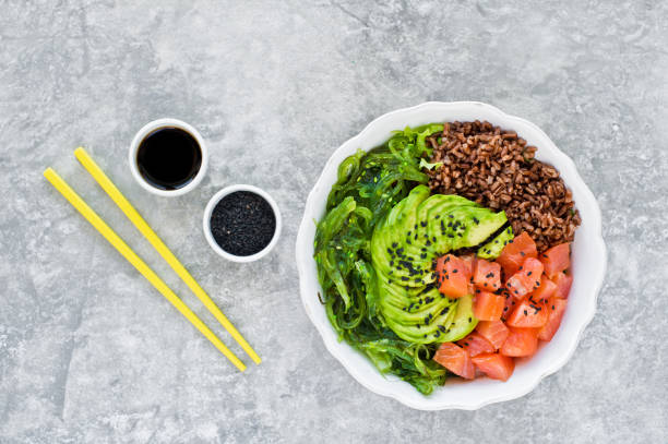 istock Salmon salad, avocado, brown rice, seaweed. Gray background, side view, space for text. 1134449660