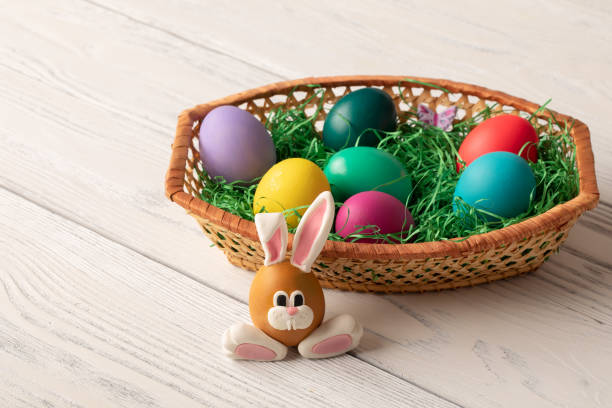 istock Bunny face funny egg with basket full of colorful easter eggs 1134449894