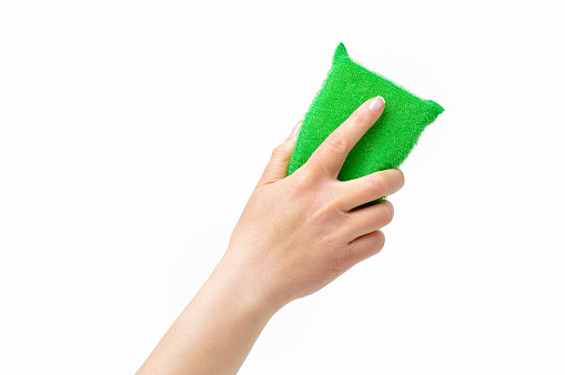 Cropped shot of an unrecognizable woman hand holding a cleaning sponge isolated on a white background