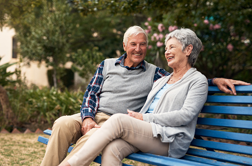 Senior caucasian couple sitting at the bench in park