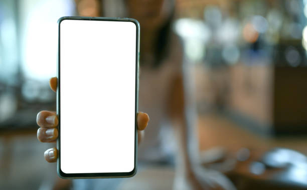 istock Women hand showing mobile phone blank screen in the cafe. 1134454759