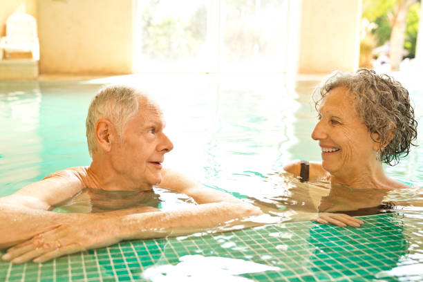 istock Smiling senior man and woman leaning at poolside 1134457046