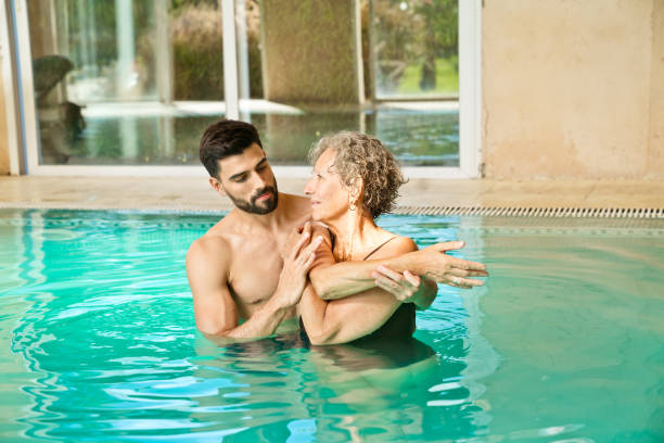 istock Instructor assisting senior woman in stretching 1134457841