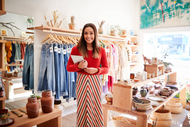 portrait of female owner of independent clothing and gift store with digital tablet - business owner imagens e fotografias de stock