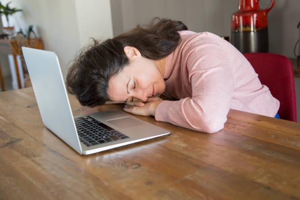 istock Young woman tired form work at laptop leaning on table 1134459629