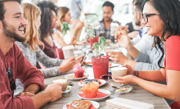 group of happy friends drinking coffee and cappuccino at vintage bar - young students people eating and talking at breakfast - friendship, trend and food concept - focus on woman eye glasses - day asian ethnicity asian culture asian and indian ethnicities imagens e fotografias de stock