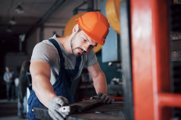 istock Experienced operator in a hard hat. Metalworking industry concept professional engineer metalworker operating CNC milling machine center in manufacturing workshop 1134460476