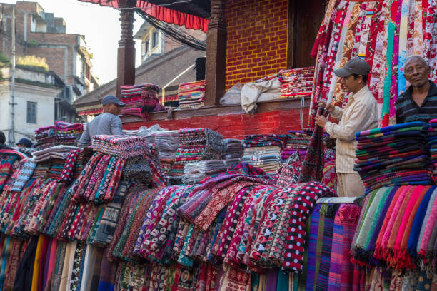 scarf seller on a market in kathmandu, nepal - nepal bazaar kathmandu textile imagens e fotografias de stock