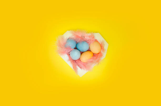 istock Painted eggs, exotic feathers in heart formed box,top view.Concept of Easter celebration 1134464975