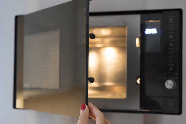istock Woman’s hand opening microwave door in the kitchen 1134465877
