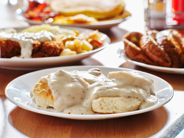 biscuits and gravy with breakfast foods on plate stock photo