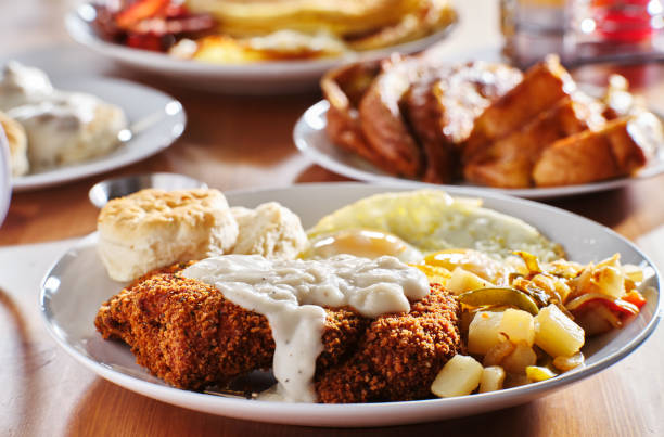 country fried steak with sunny side up eggs and biscuits country fried steak with sunny side up eggs and biscuits with other breakfast foods steak and eggs breakfast stock pictures, royalty-free photos & images