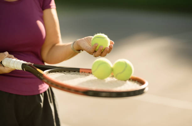 selecting a ball for service - tennis serving playing women imagens e fotografias de stock