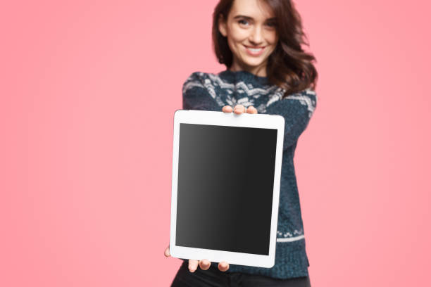 istock Charming woman presenting tablet to camera 1134468858