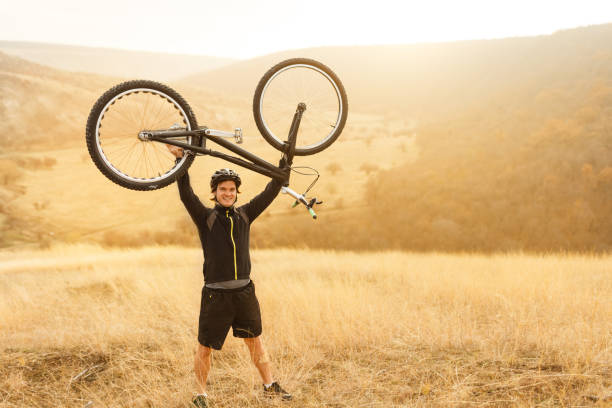 istock Sportsman lifting bicycle over head 1134468886