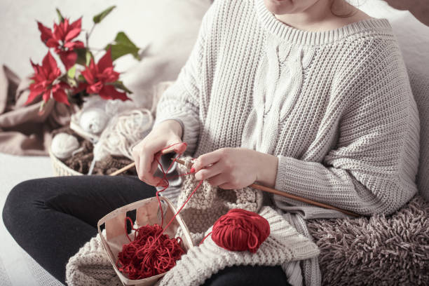 istock woman knits knitting needles on the couch 1134469156