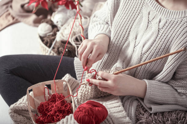 istock woman knits knitting needles on the couch 1134469160