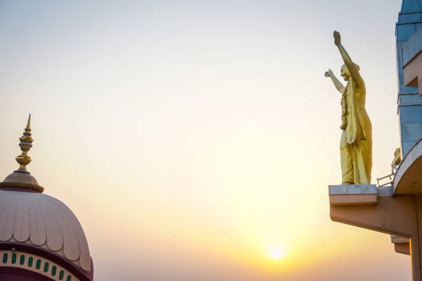 skulptur von vaishnava auf dem gebäude von samadhi srila prabhupada auf dem hintergrund des sonnenuntergangs. mayapur, indien - hase temple stock-fotos und bilder