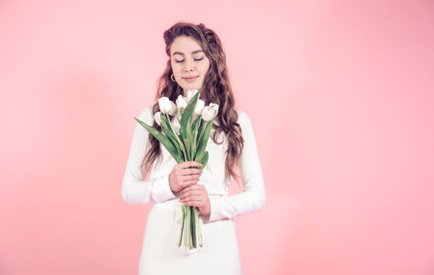 istock Young girl with tulips on a colored background 1134471785