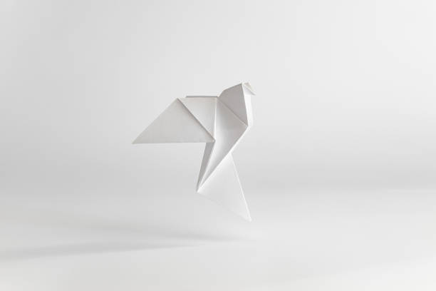 origami paloma hecha de papel blanco sobre fondo blanco llano. concepto mínimo. - paloma blanca fotografías e imágenes de stock