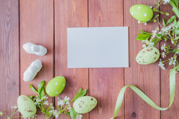 istock Mockup white greeting card and easter eggs with white spring flowers on a wooden background 1134482169