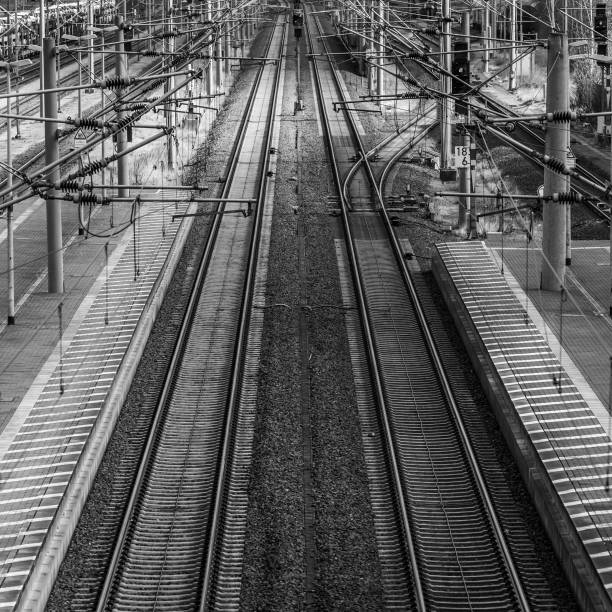 istock Perspective view of railway tracks with overhead lines next to a platform 1134482861