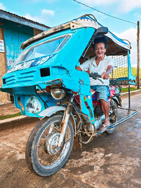 Blue colored old tricycle with old age male driver Taytay, Palawan Province, Philippines - February 14, 2010: Blue colored old tricycle with old age male driver near the wet market philippines tricycle stock pictures, royalty-free photos & images