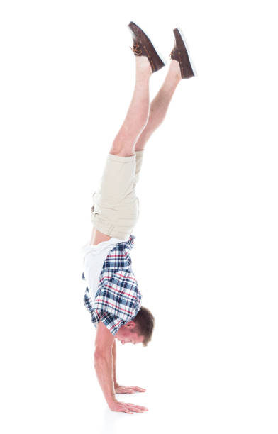 istock Handsome man in shirt and shorts is doing a handstand 1134493211